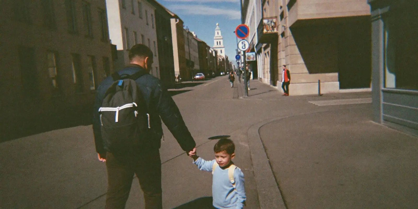 Vater geht mit seinem Sohn Hand in Hand durch eine Winterthurer Gasse